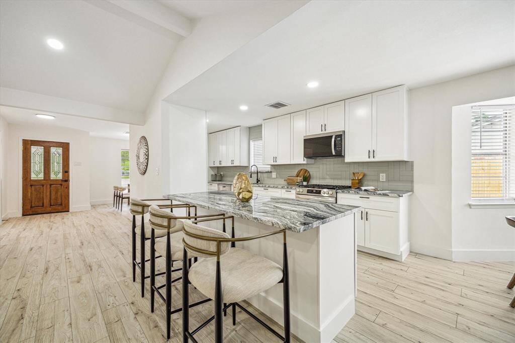 This kitchen includes a center island with breakfast seating
