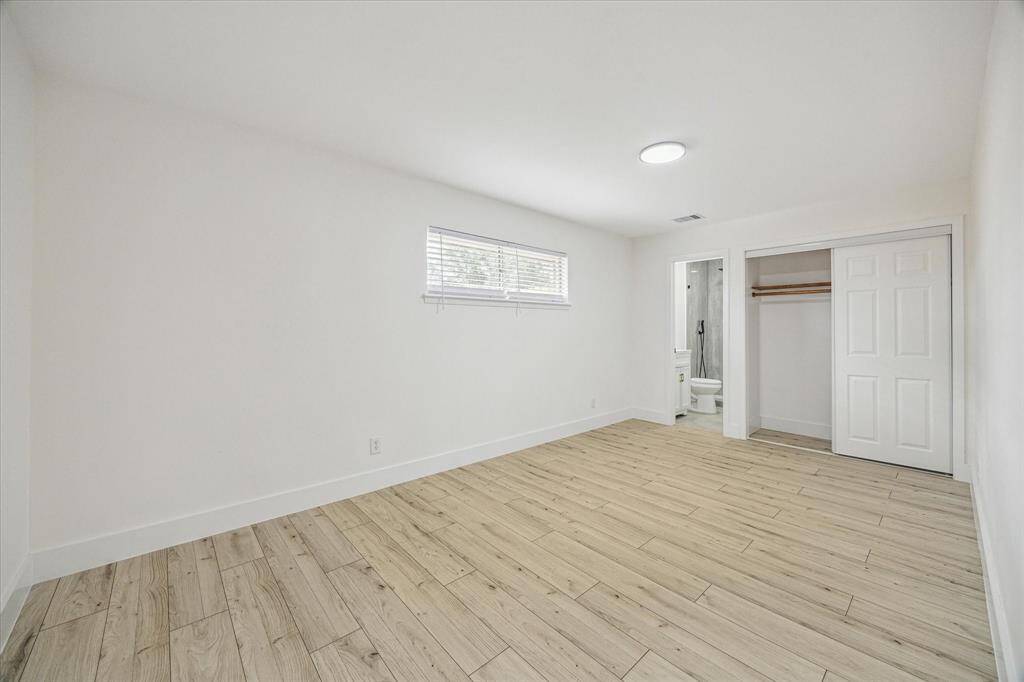 Perfect for extended stays or multigenerational living, this generously sized guest suite offers an en-suite bath complete with a frameless shower, rainfall shower head, and wand.