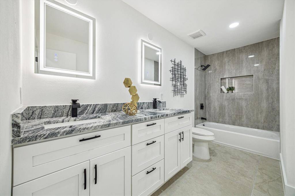 Beautifully appointed with a tub/shower combo, double sinks, and high-end features like a waterfall shower head and defrosting mirrors