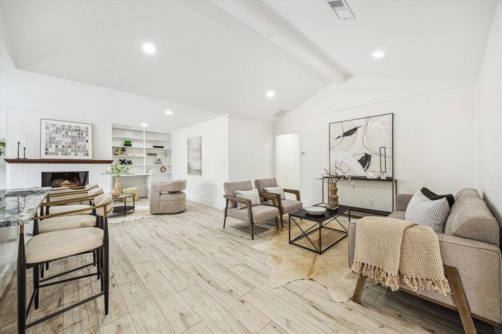 Enjoy this light-filled living room featuring recessed lighting and custom built-in shelving