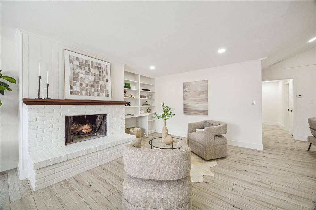 Anchored by a charming wood-burning fireplace, the living room offers the perfect space to relax or entertain.