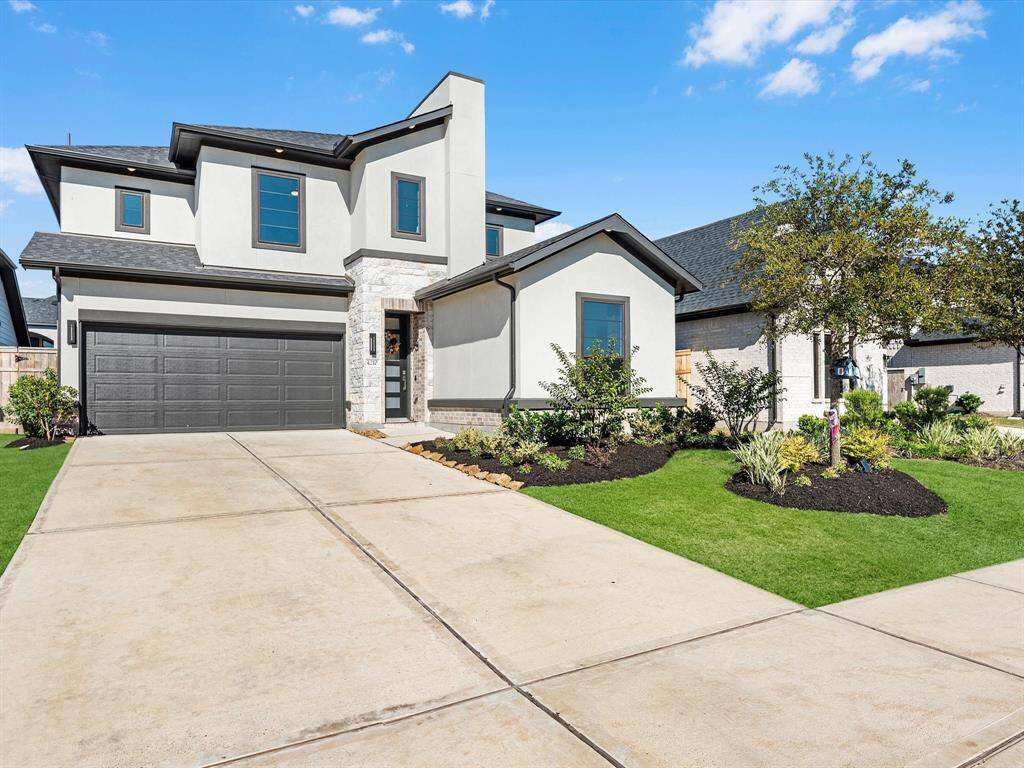 A modern 2 story home, featuring a clean contemporary modern design with light stucco and accent stone with a focus on clean lines and elegant exterior.