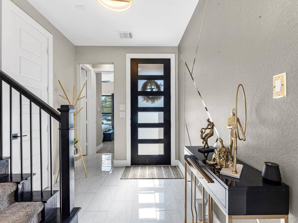 Welcome to this stunning modern Home! As you step inside, you are greeted by a chic entryway featuring an upgraded sleek black door with frosted glass panels for privacy and allowing natural light to pour into the house The foyer sets the tone with the polishing flooring adding a touch of elegance and leading you to a beautifully designed space