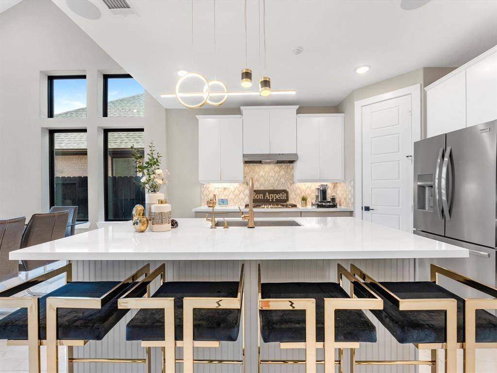 Seamlessly combining  modern and functionality, the kitchen showcase a spacious island with a sleek countertops and upgrades undercabinet lighting, sliding doors custom faucet, upgraded stainless steel appliances and state of the art water filtration.