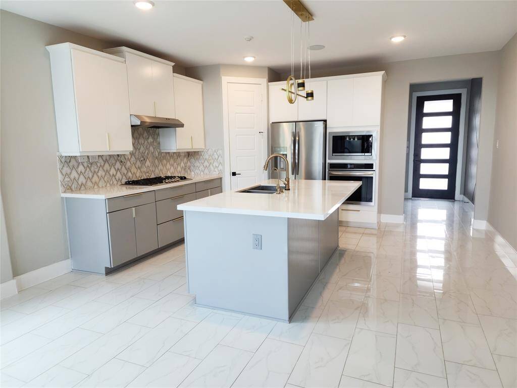 The floors are a beautiful upgrade on this home,  the sleek polished tile curated to accommodate the modern style  and complemented by the upgrade of the backsplash and the two tones cabinets made this area an instant appeal for the chef of the family.