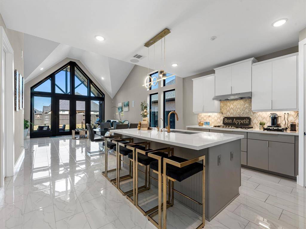 the  modern residence features an Open concept  with modern touches and a  pointed vaulted ceiling with a home theater speaker and sound system already installed make this home the perfect space for family and entertaining