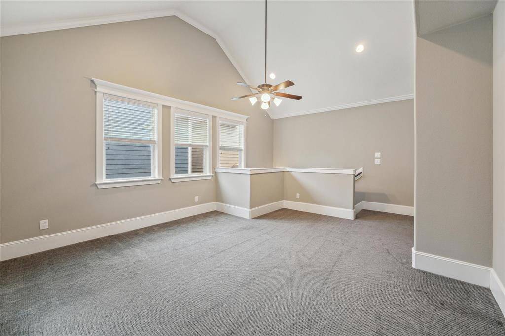 Offering versatility and privacy, this spacious garage apartment living area is designed for comfort and functionality. Vaulted ceilings enhance the sense of space, while neutral tones and soft carpeting create a warm and inviting atmosphere. Large windows allow natural light to fill the room, adding to the airy feel.