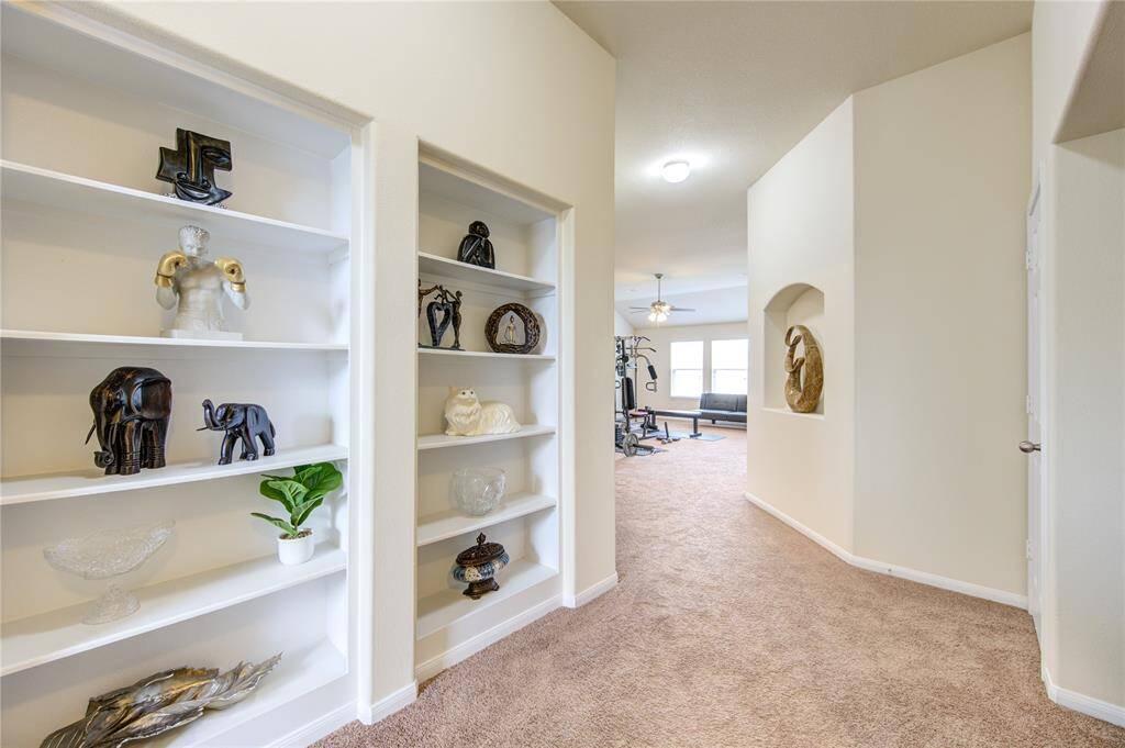 Built-in shelving at the top of the stairs provide ample space to showcase your choice of