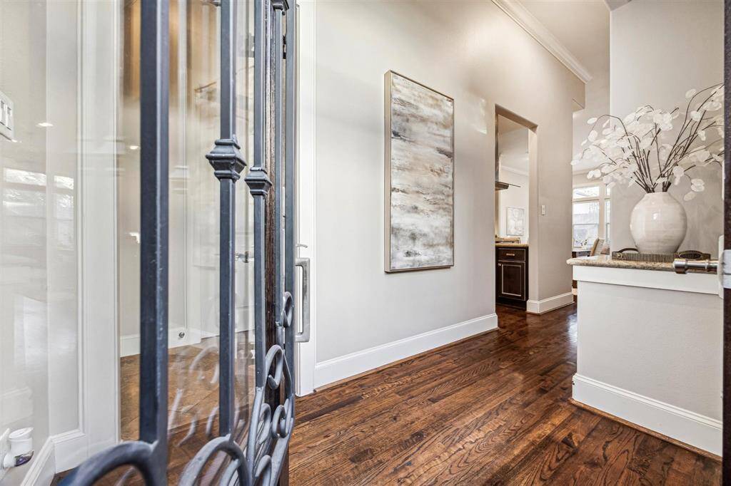 Welcoming Home! The entry features elegant hardwood flooring, neutral walls, and a decorative nook, leading into a bright living area.