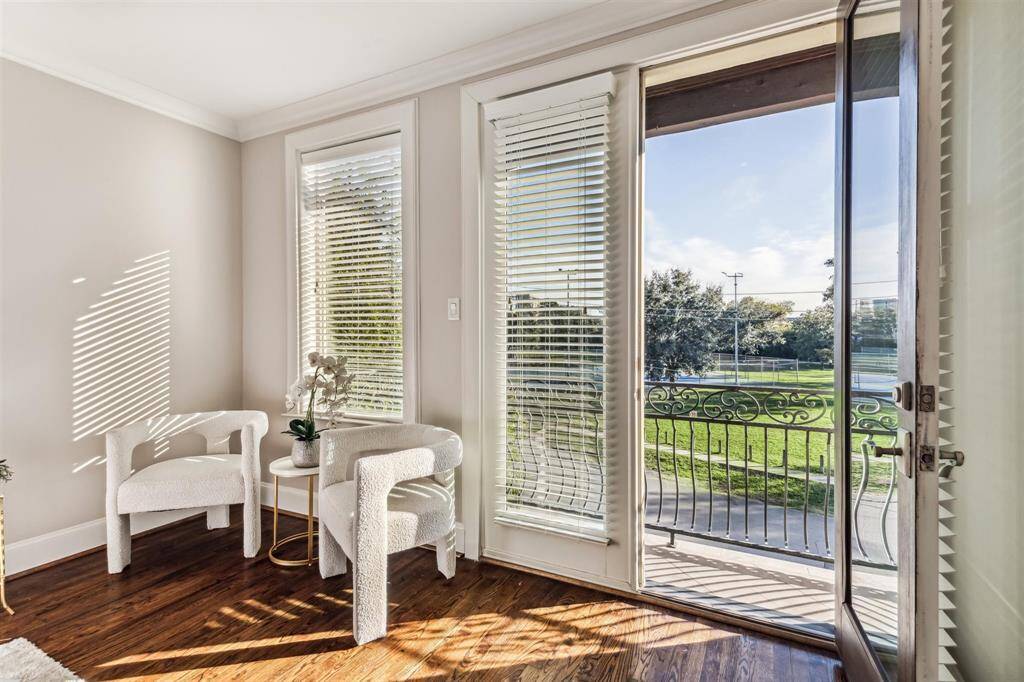 Bright and inviting room with large windows and a door leading to a balcony.  Perfect for relaxation and natural light.