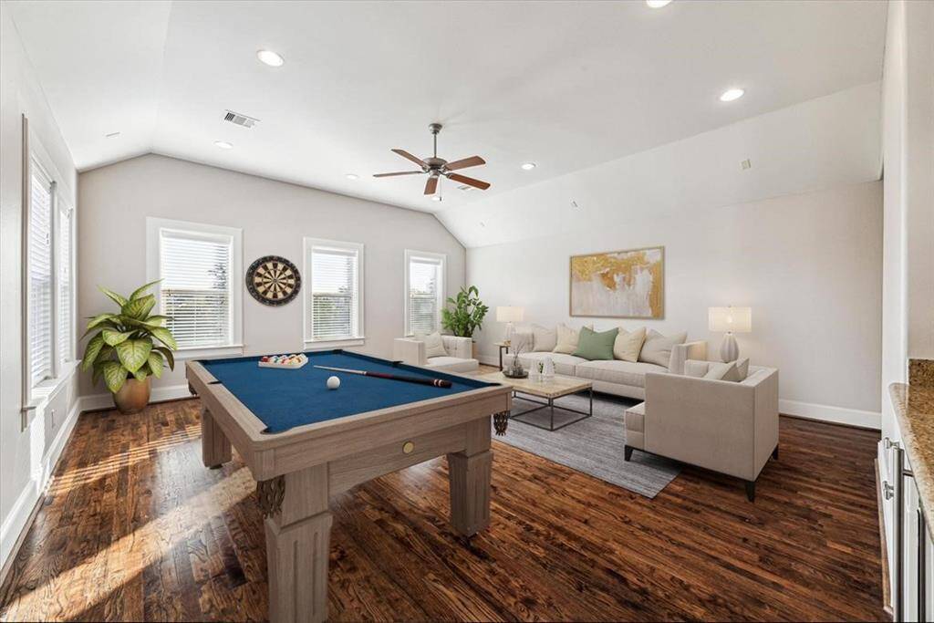 Third floor flex room being showcased as an entertainment room with wood floors and lots of windows provide ample natural light