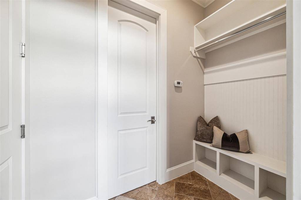 Mudroom with a built-in bench, storage cubbies, and coat hooks.