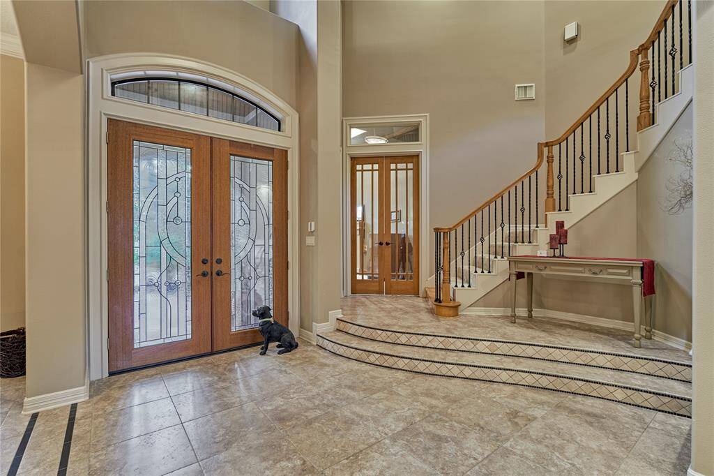Statement front door entry with elegant staircase to second floor.