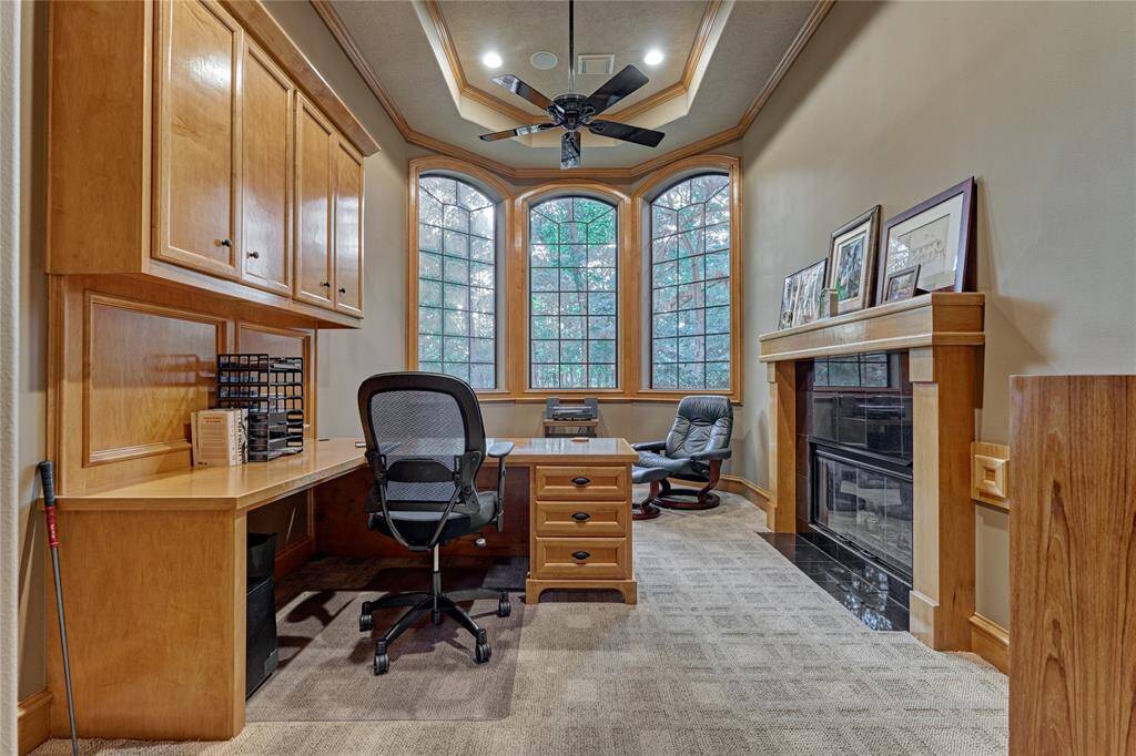 The study boast of custom built-in cabinetry and enjoys a tree-lined front yard view that brings nature inside.