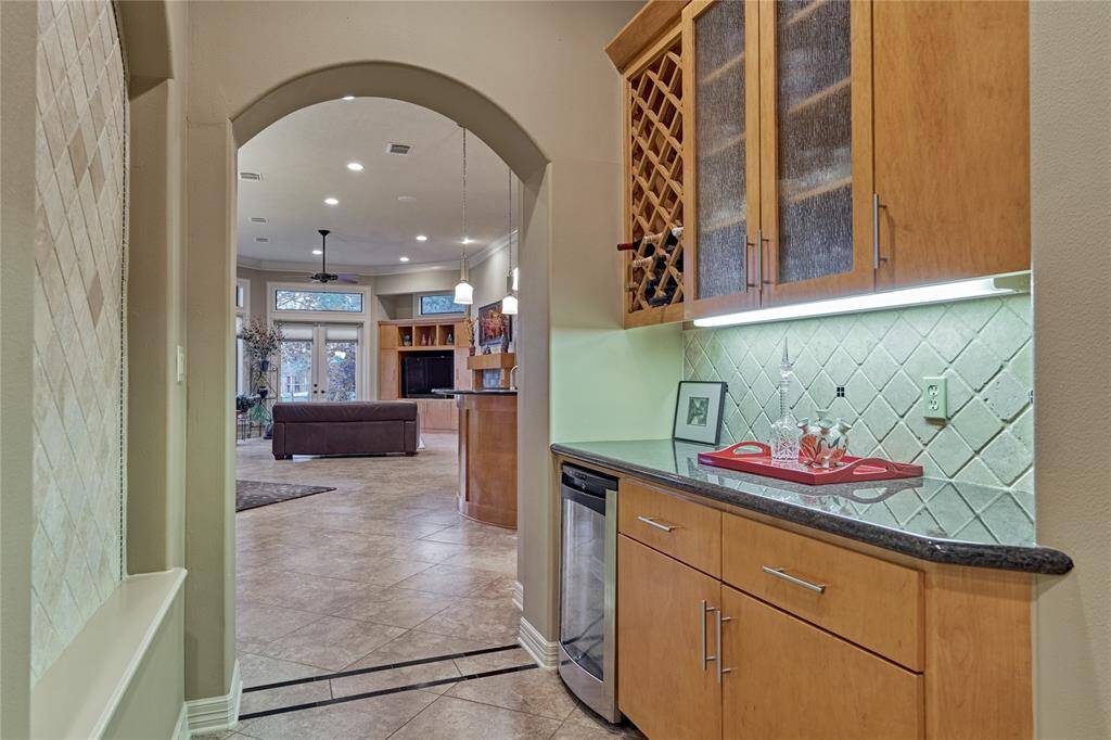 A butler's pantry is perfectly positioned off the kitchen between the formal living and dining and features built-in wine storage and a beverage fridge.