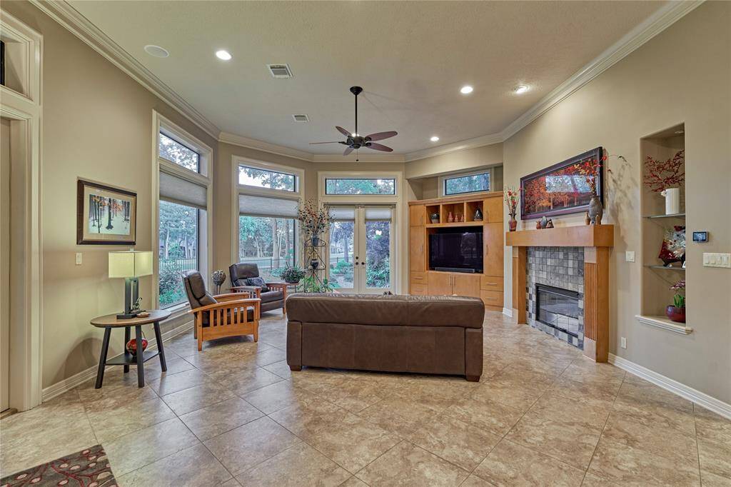 A second fireplace in the family room with custom built-in cabinetry and natural light pouring in through the windows.
