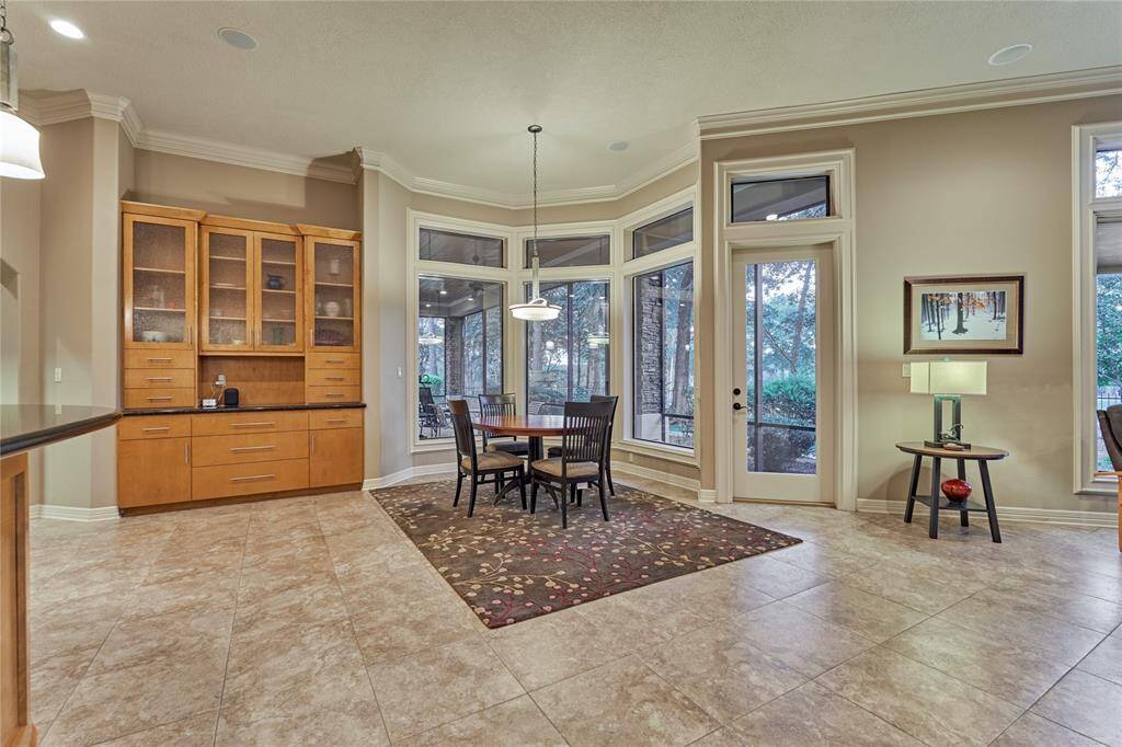 The spacious breakfast area overlooks the lush green backyard through bay picture windows.