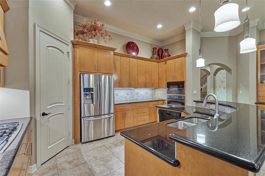The dark granite countertops are a good contrast to the rich wood cabinetry.