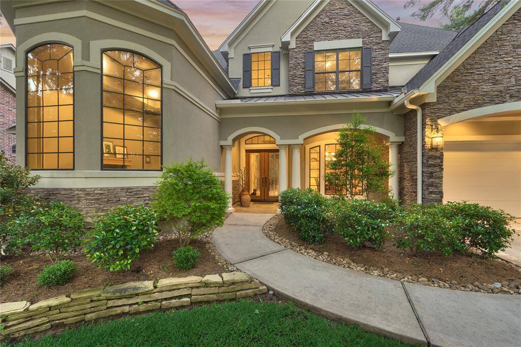The entrance of the home offers a wood and glass double door entry and the stately columns add a touch of southern flare.
