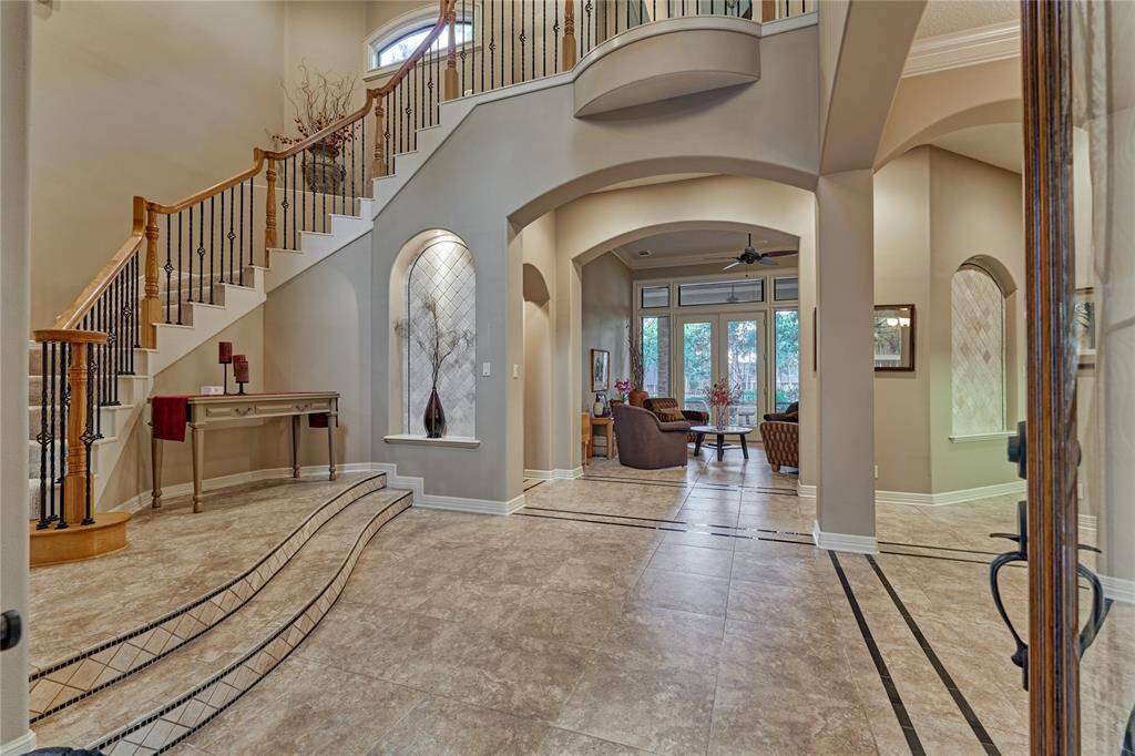 Grand 2-story entry with sweeping staircase and a custom art niche just below that adds a perfect touch of elegance to the foyer.