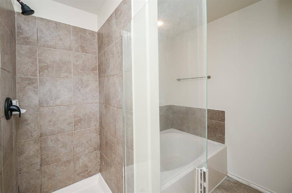 Luxurious primary bathroom featuring a separate standing shower and elegant bathtub.