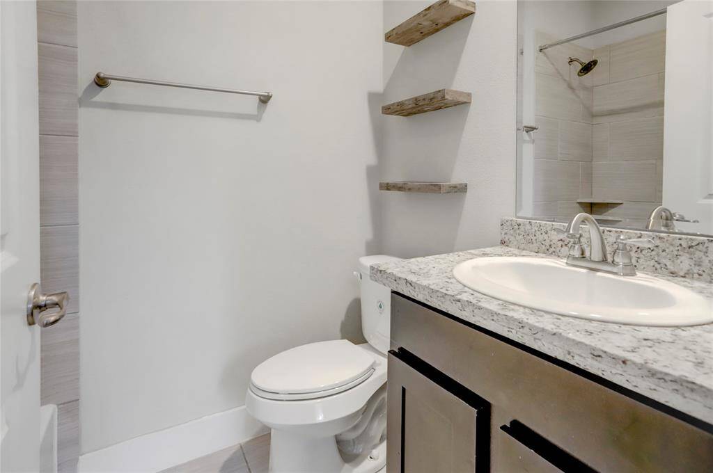 1st Floor Secondary Bathroom featuring floating shelves & tub/shower.