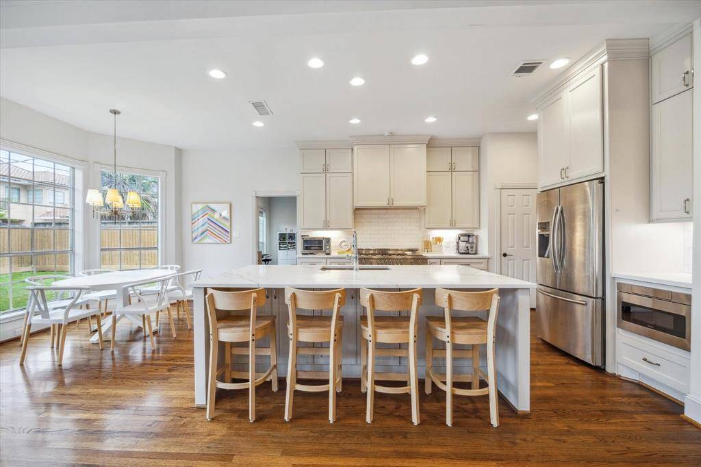 This spectacular kitchen features a large island with breakfast bar seating, along with a spacious breakfast area by the windows, providing a bright and inviting space for casual dining.