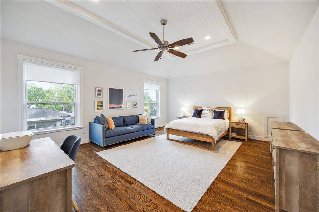 The expansive primary bedroom up features a custom ceiling treatment, recessed lighting and a ceiling fan, creating a bright and airy atmosphere. Large windows offer abundant natural light, while the spa-inspired en-suite bath provides a serene retreat.