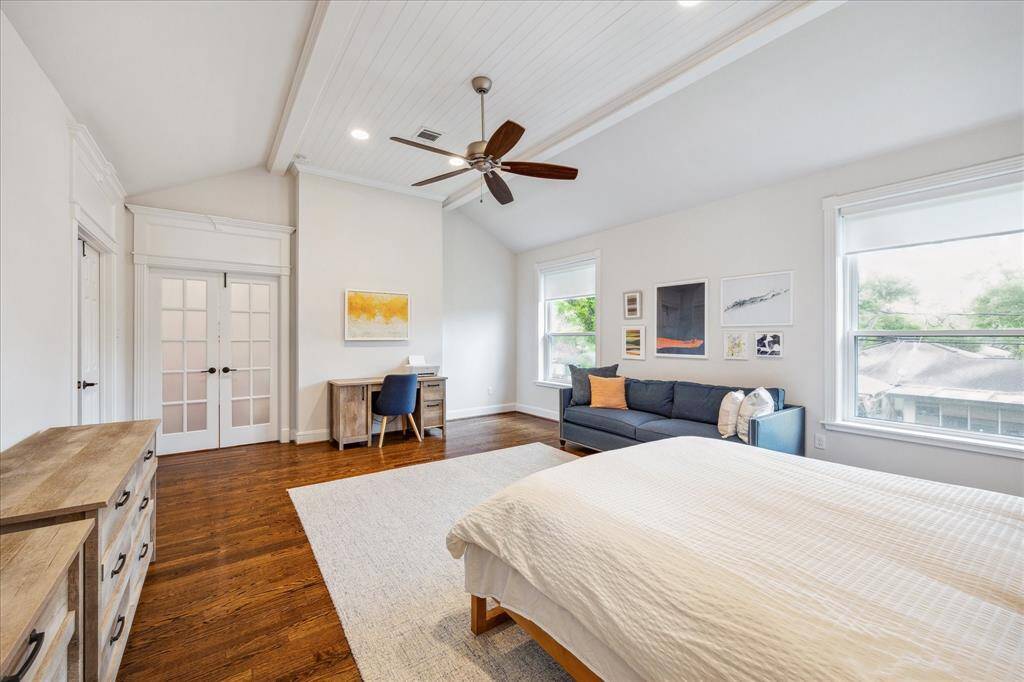 Upon entering the primary suite through double doors, you'll be greeted by a custom ceiling treatment with intricate trimmed detailing. The south-facing windows fill the room with natural light, enhancing the spacious feel.