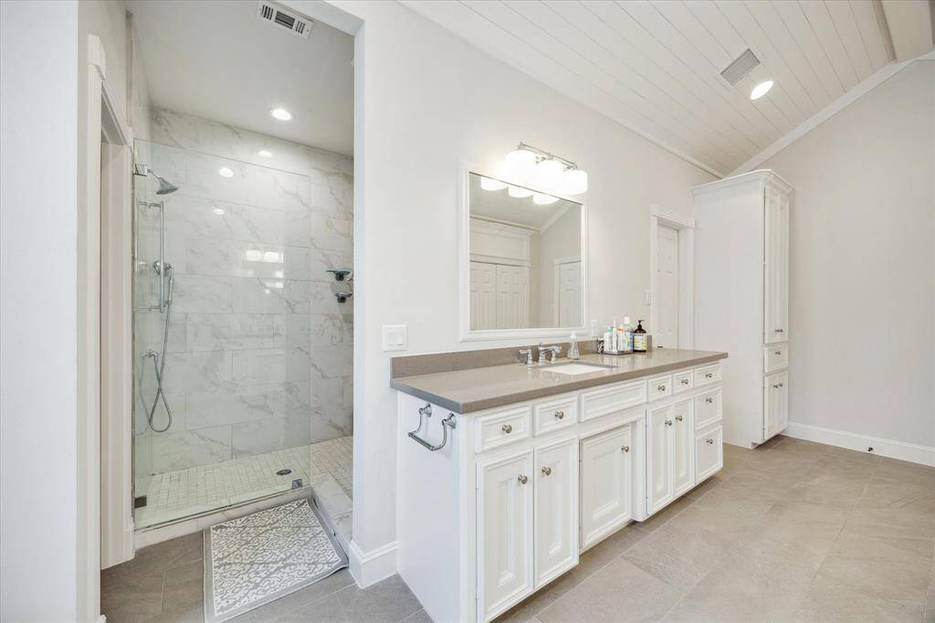 The walk-in shower, featuring frameless glass, is thoughtfully positioned adjacent to an oversized window, offering both privacy and natural light. Nearby, you'll find a private water closet and two generously sized walk-in closets.