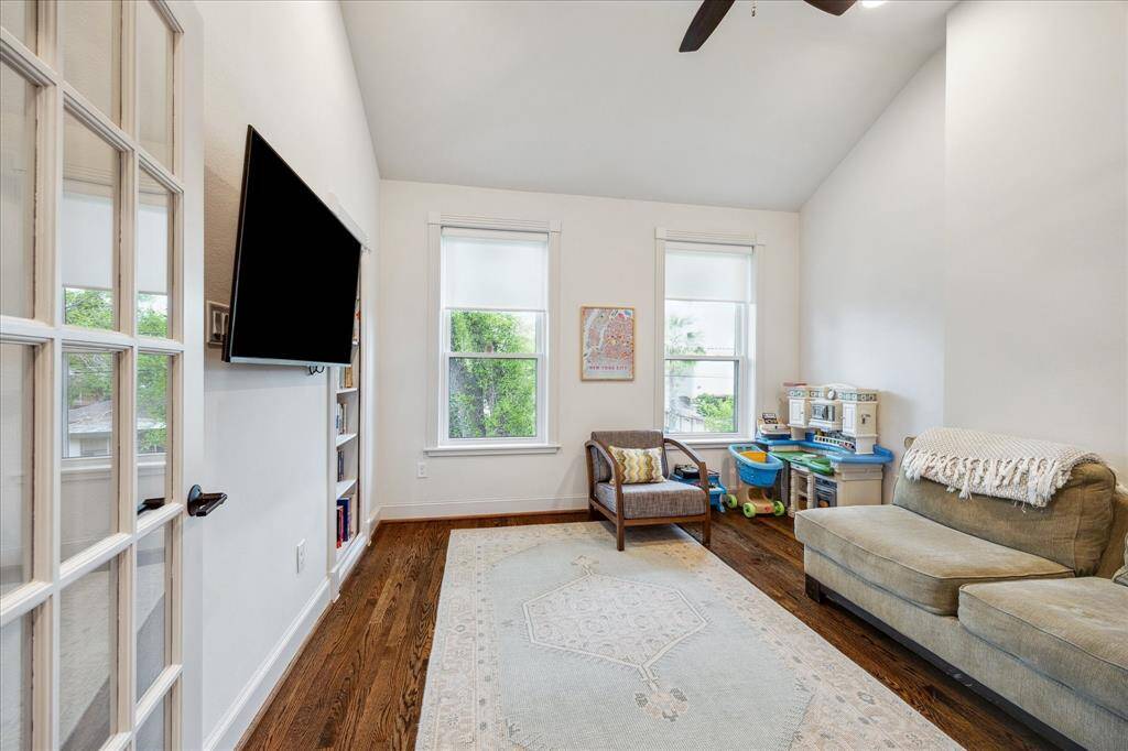 Just off the primary bedroom, the home office is bathed in natural light from south-facing dual-pane windows. A built-in shelving unit complements the space, while a cedar-lined closet adds storage. This versatile room can easily function as a bedroom, nursery, home gym or playroom, as shown in this image.
