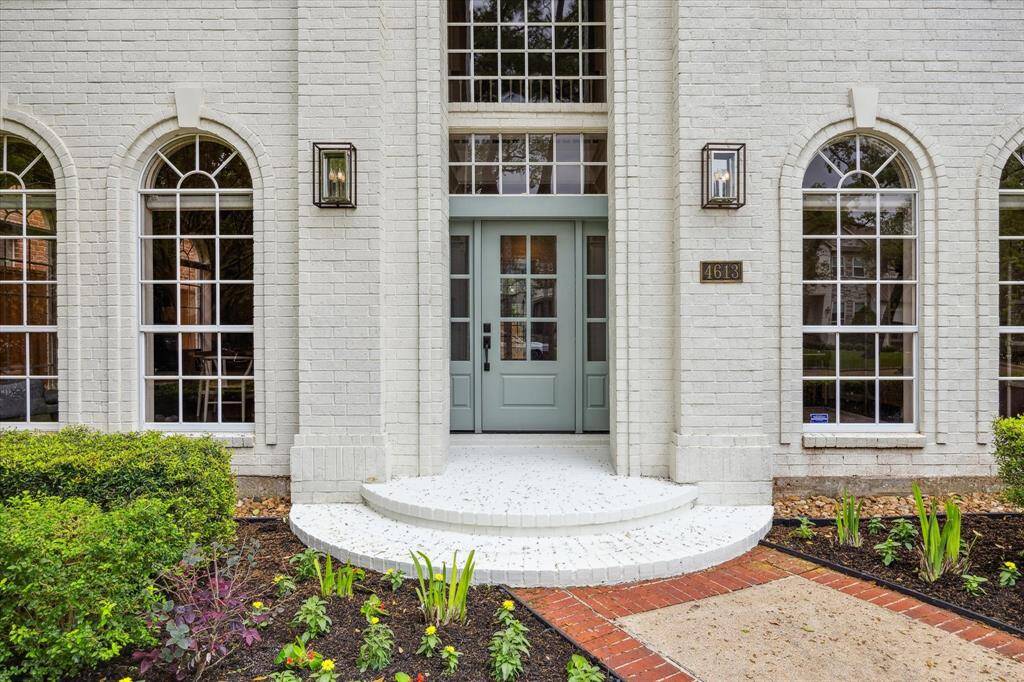 The grand entry showcases an elegant front door flanked by sidelights and crowned with transom windows, allowing natural light to stream into the home and setting the tone for the refined interiors beyond.