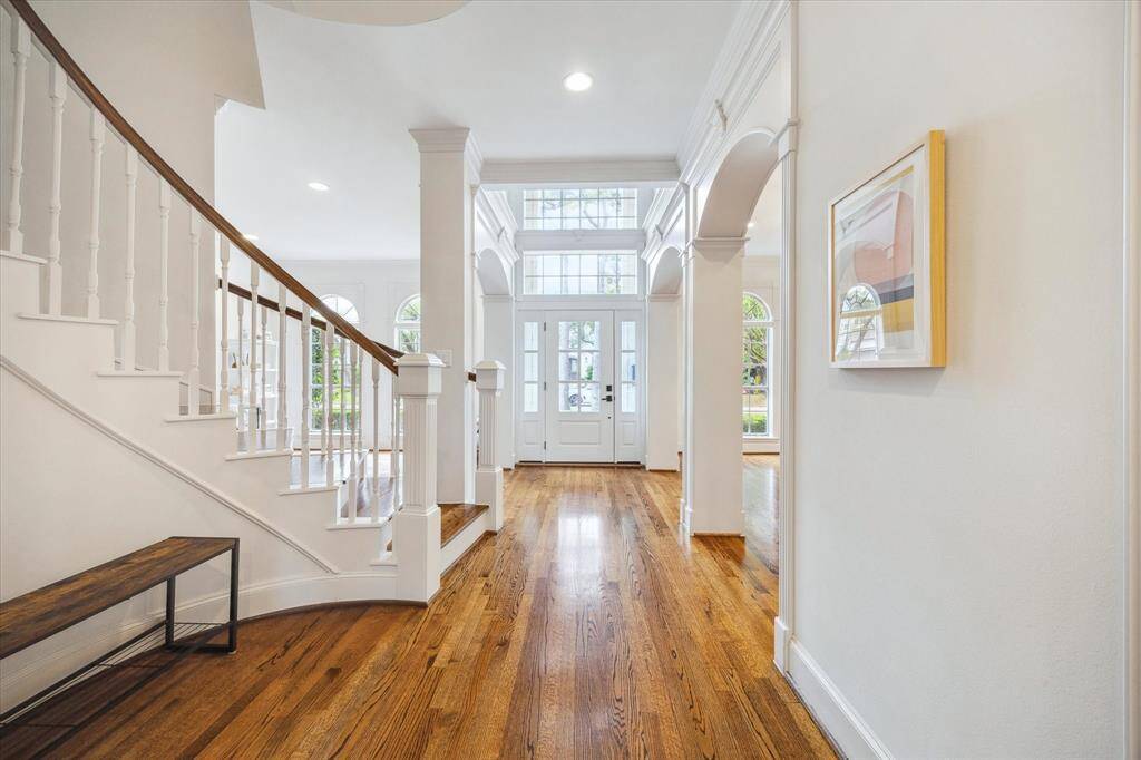 From the central hall, looking back toward the entryway, there is a coat closet to the left that extends beneath the staircase, offering additional storage. We love all the windows that brings in so much natural light!