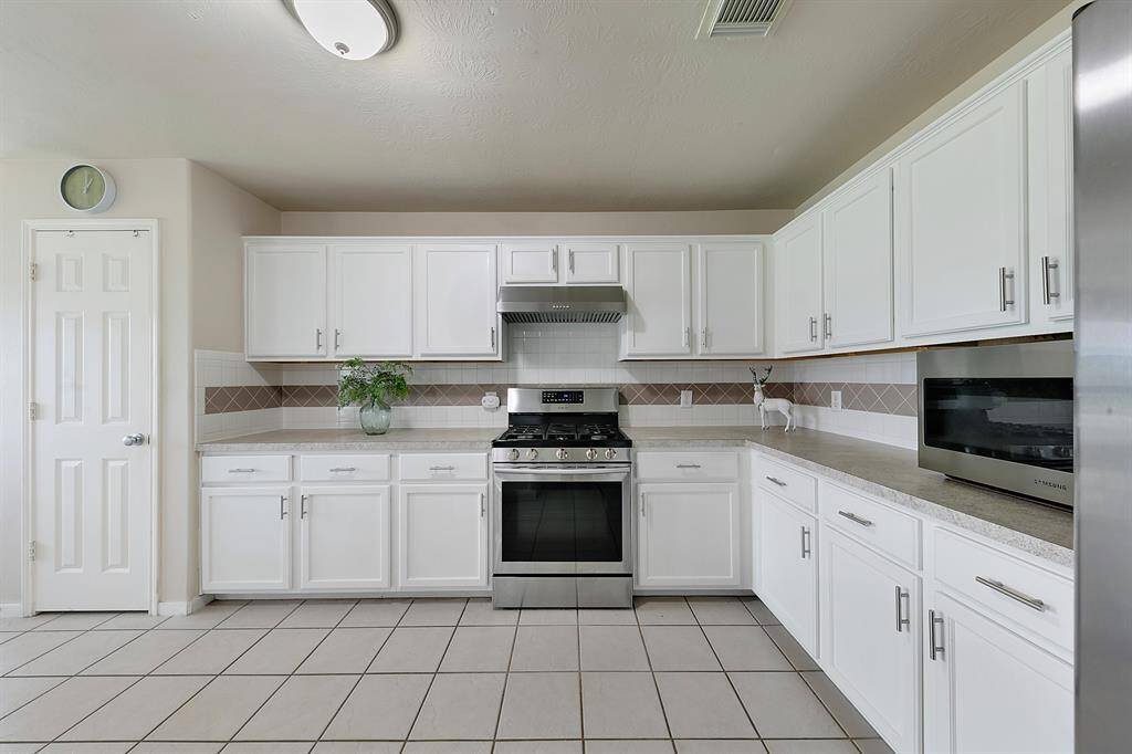 The kitchen featuring ample cabinet and counter space for all your culinary needs. With a convenient pantry, it offers both functionality and plenty of room for storage, making meal prep a breeze.