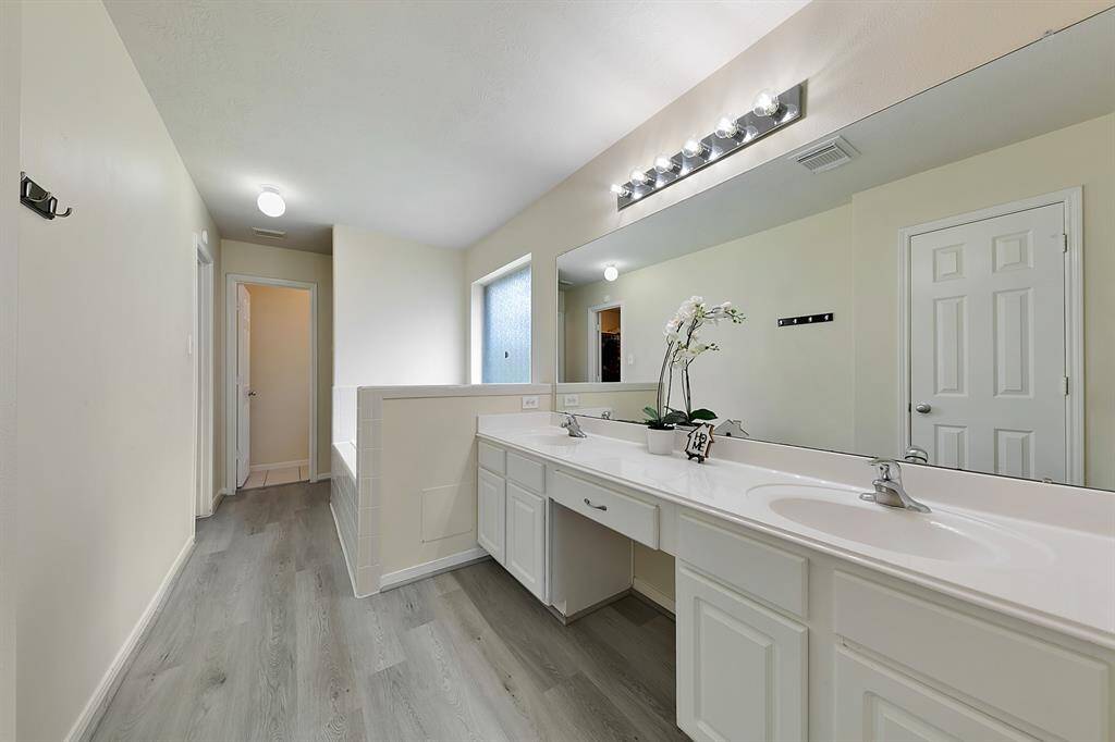 The luxurious primary ensuite features dual sinks and a vanity for added convenience, a deep soaking tub and separate shower for ultimate relaxation. A spacious walk-in closet complete this functional retreat.