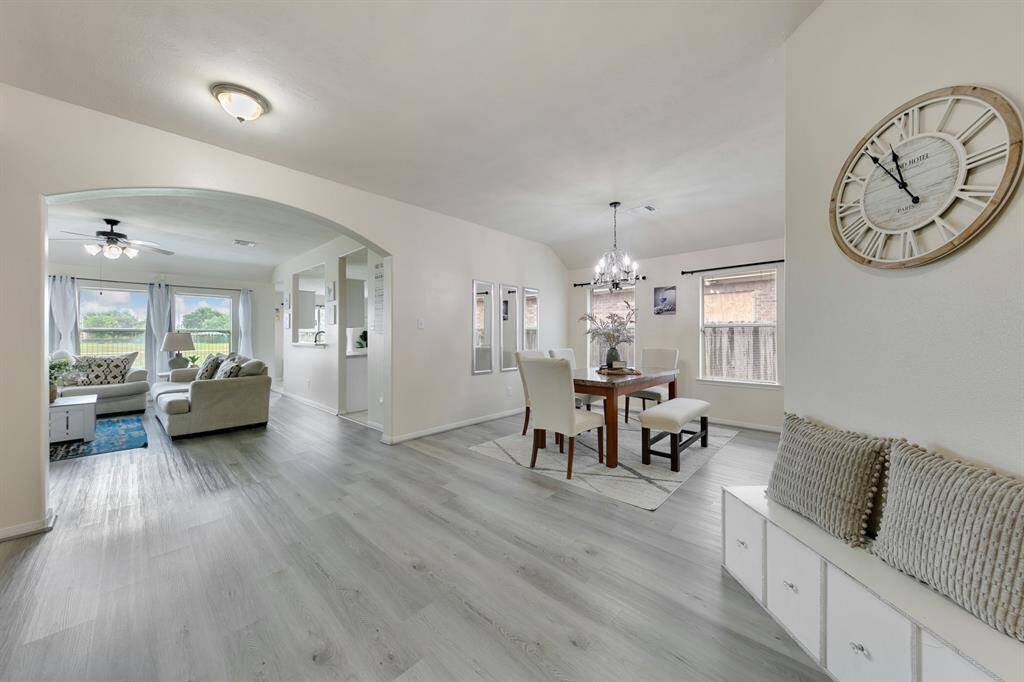 The spacious formal dining room is bathed in natural light, thanks to its large windows that offer a bright, welcoming atmosphere. With ample space for gatherings, it provides an elegant setting for special occasions.
