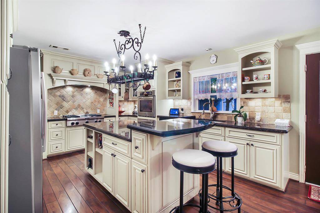 Island kitchen offers plenty of workspace, extra storage space, drawers, cabinets, electrical outlets, plus thoughtful seating area for two.