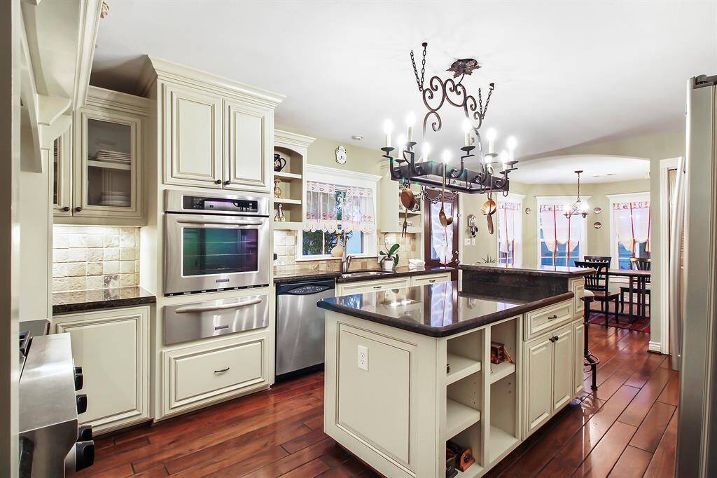 I love this kitchen… Plenty of space and function. All high-end stainless steel KitchenAid appliances. Full size wall-oven is complemented with a heating drawer underneath. Notice wrought iron ten-arm kitchen island chandelier, which is complemented with spotlights and under-the -cabinet recessed lights.