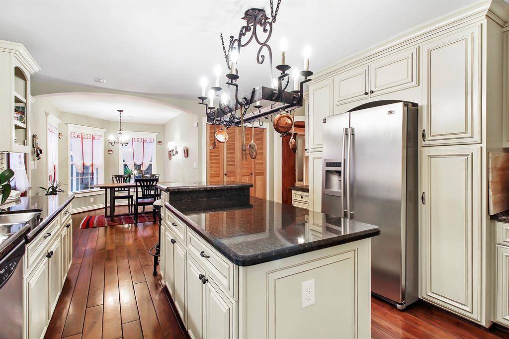 A 2008 addition to the house is a cozy breakfast area and small but functional laundry room. Notice dark hardwood flooring and antiqued floor to ceiling cabinets. Thick granite countertops all around.