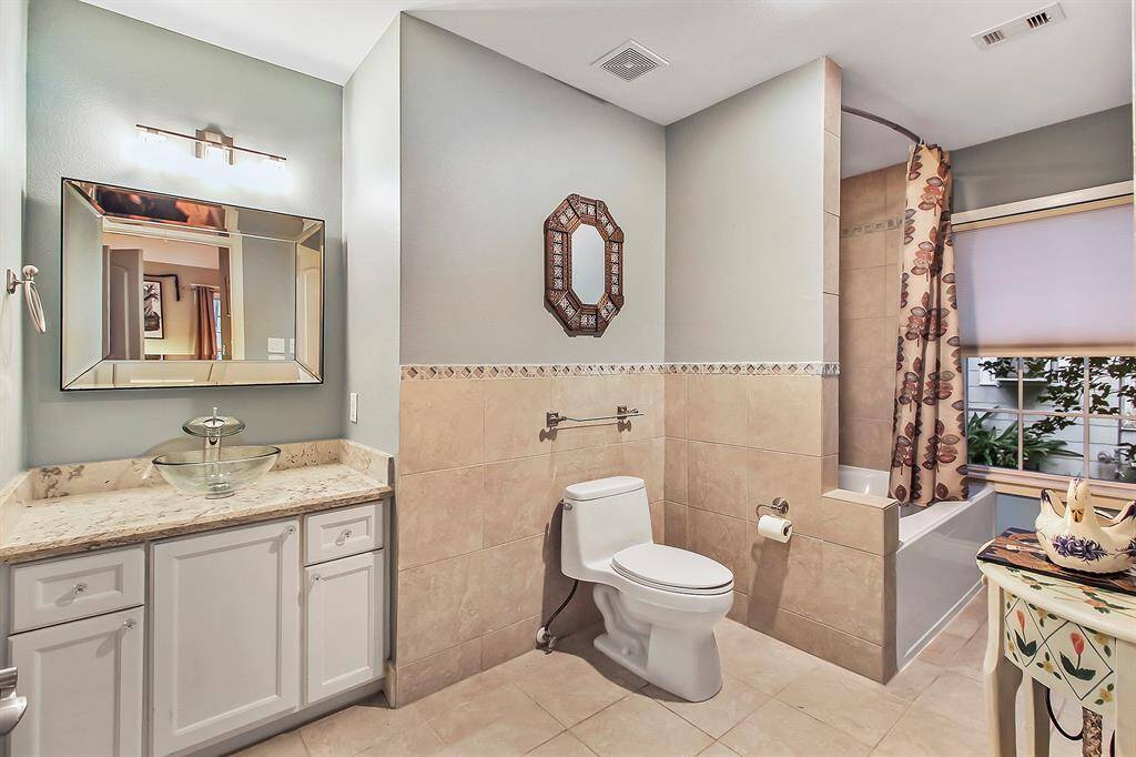The third en suite bathroom is complete with tub/shower combo, toilette, and bowl hand wash bin mounted on granite countertop cabinet. Tasteful tile work characterizes this bathroom as well. Observe the bathroom window as well.
