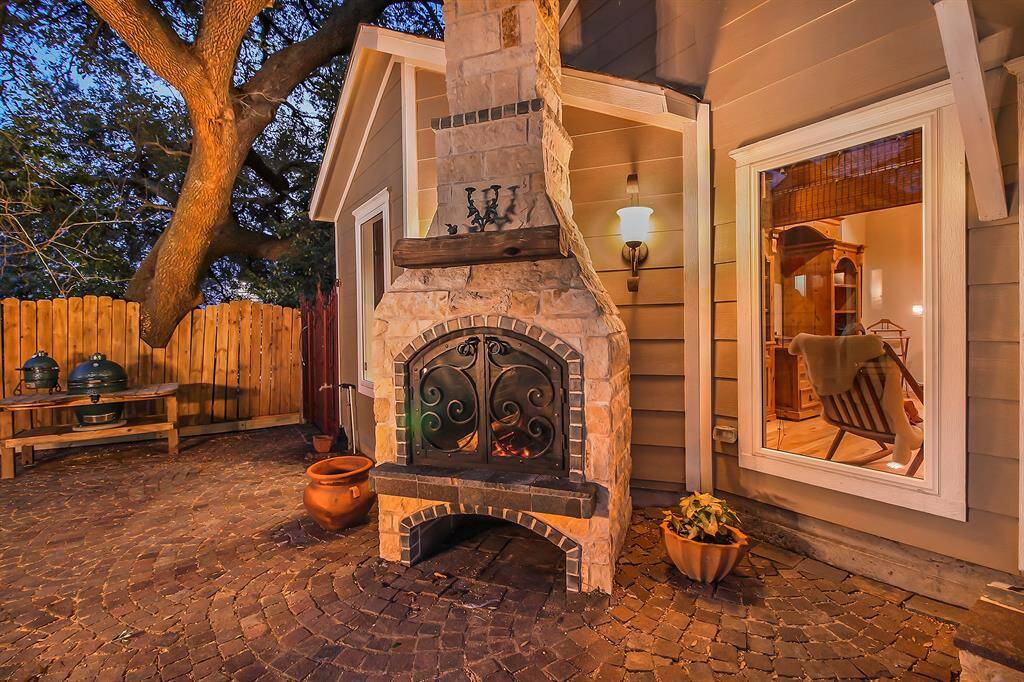Close-up of the custom built, fully functional wood burning fireplace - a masterpiece! Fire resistant window and wrought iron door assembly, custom built in Pennsylvania. Food crane in the fireplace makes outdoor cooking possible. The fireplace was hand built out of Austin White Limestone with granite and brick enhancements.
