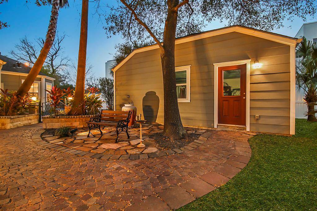 Grab your favorite book and enjoy the water fountain area under the tree canopy. Observe side door access to the two-car garage.