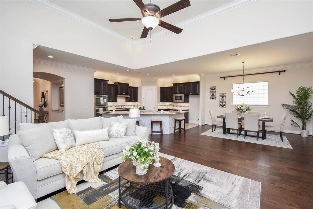 The open-concept layout connects the living, dining, and kitchen areas, perfect for entertaining or everyday living. Enjoy dark espresso cabinets, granite counters, stainless steel appliances, and a spacious island with bar seating—all overlooking the cozy and elegant living space.