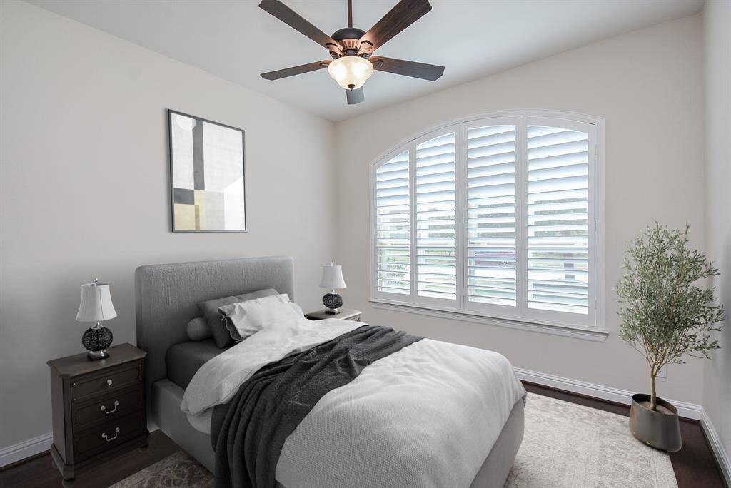 This is the second secondary bedroom, offering hardwood floors, a ceiling fan—ideal for family, guests, or as a comfortable personal space.