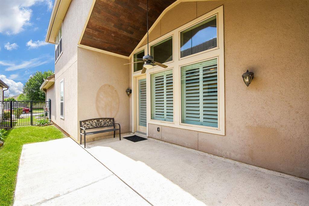 Enjoy the outdoors in this spacious covered patio, complete with a ceiling fan and wood-accented ceiling—perfect for relaxing evenings or weekend BBQs, rain or shine.