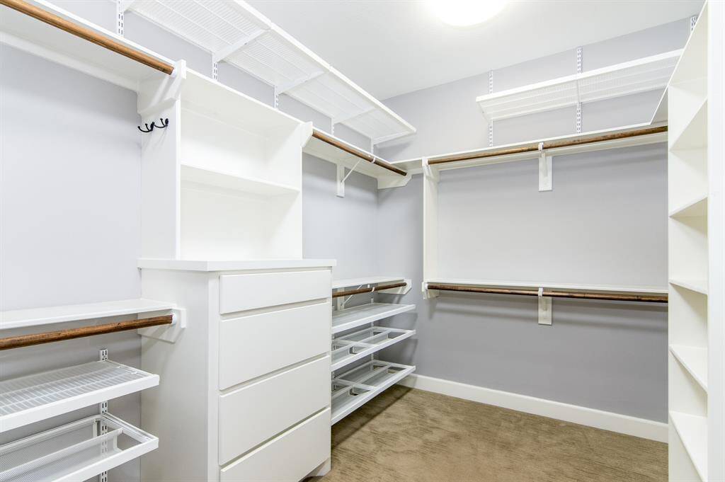 The large primary suite walk-in closet features custom built-ins and elfa storage.