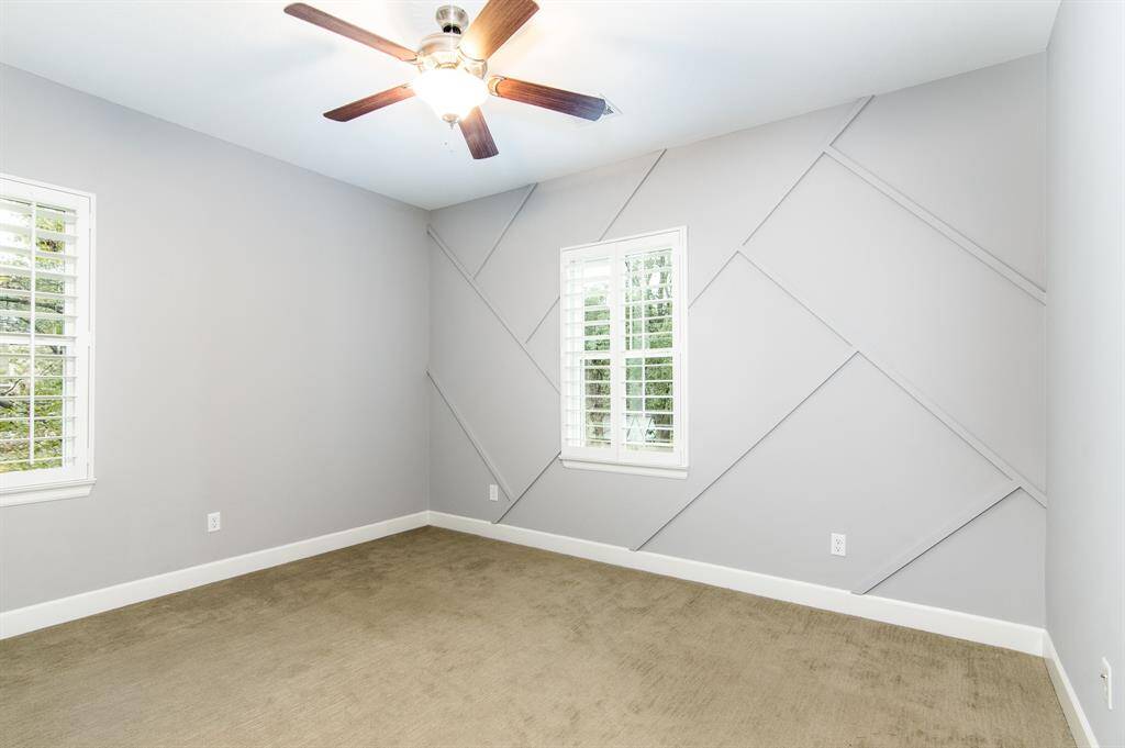 A secondary bedroom features custom wall-trim.