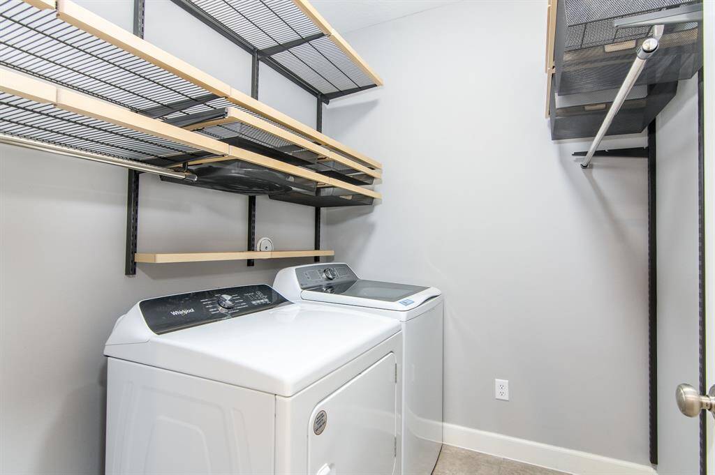 The washer, dryer and custom elfa storage all stay in this nicely equipped utility room.