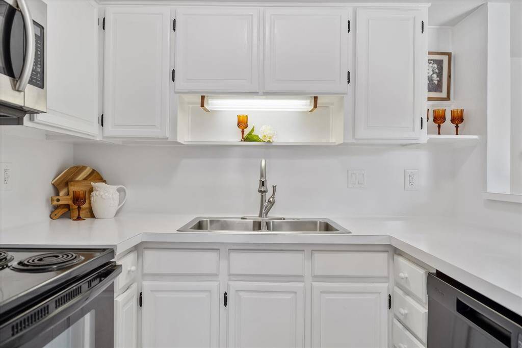 Double stainless sink, open display shelving.