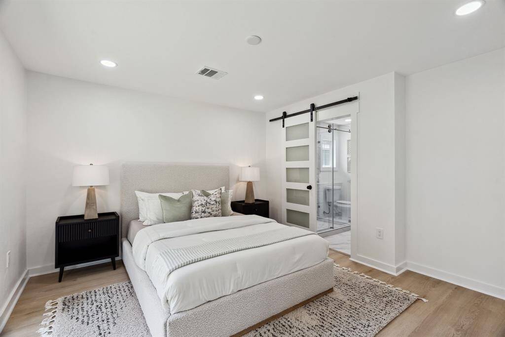Primary suite with direct bath access and contemporary sliding door feature.